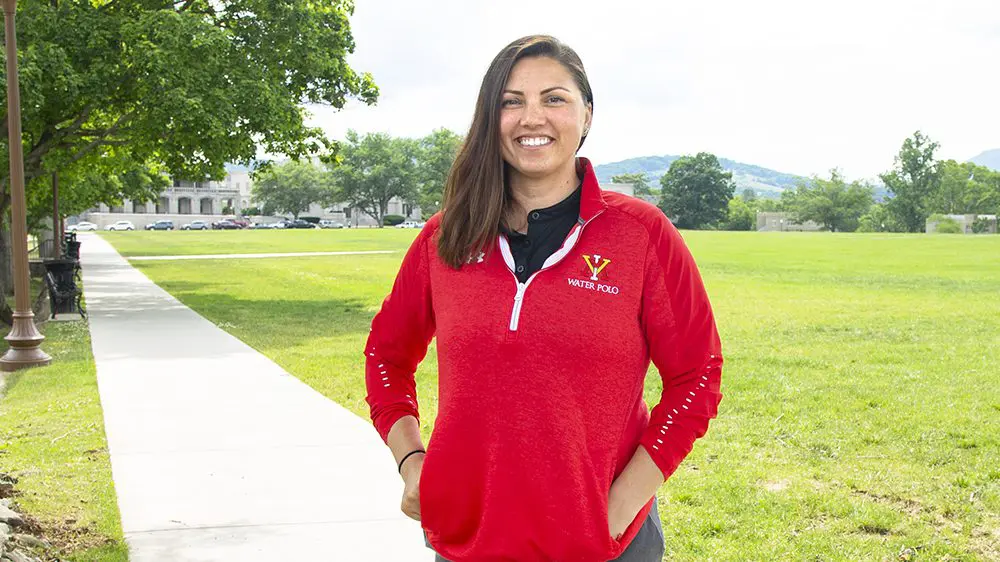 Coach Montenegro smiling with hands in pockets.