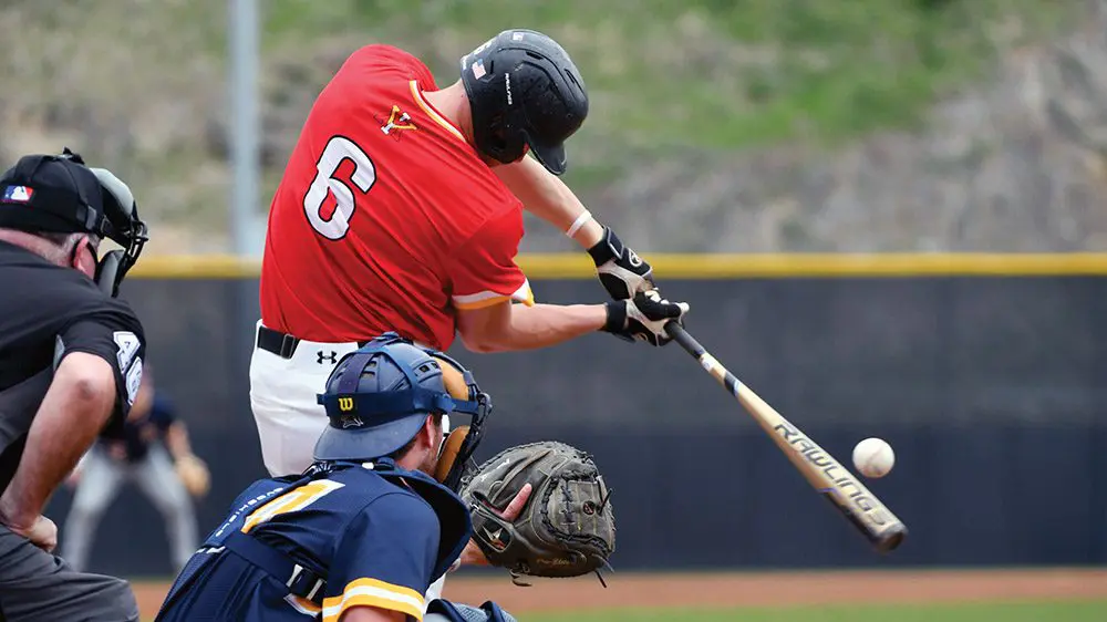 Baseball player hitting ball with bat.