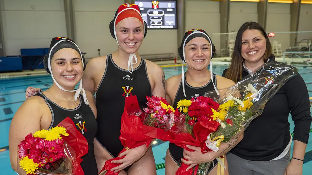 Danielle Montenegro, water polo coach, posing with three 1st Class cadet-athletes, Sydney Shettleroe ’23, Katie Lloyd ’23, and Gia Donatelli ’23.