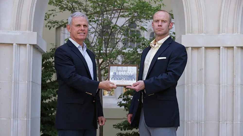 Steve Walker ’71 and Stephen M. Walker II ’04 hold a photo of the 1927–28 rat basketball team.