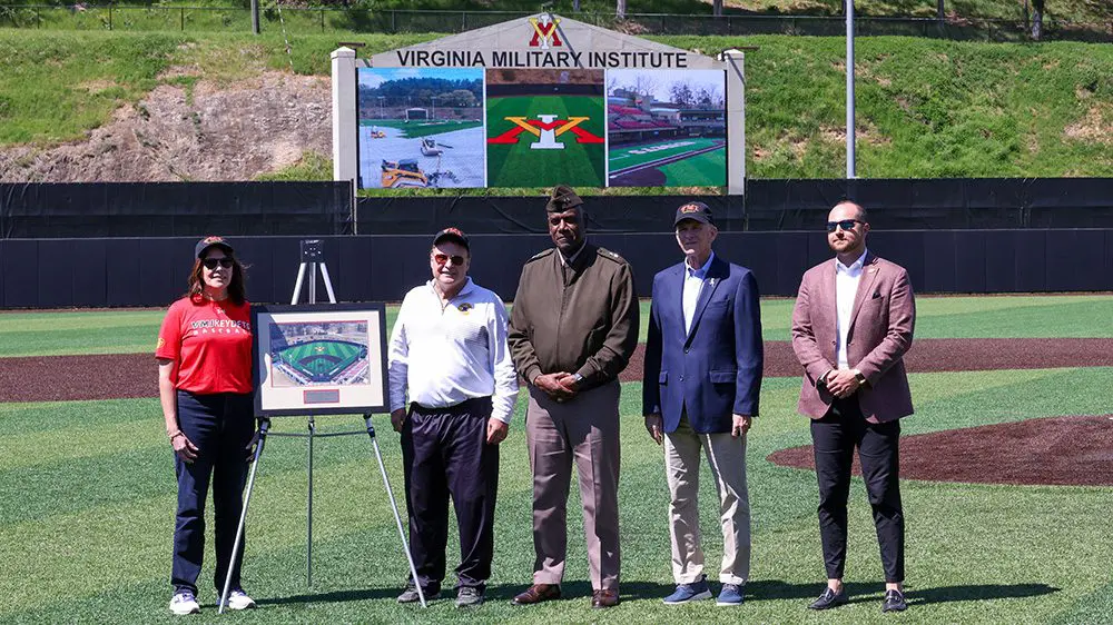 Mike Lamore '85, Susan Lamore, Maj. Gen. Cedric Wins '85, Andrew Deal '12, and Jim Miller stand on newly named Lamore Field