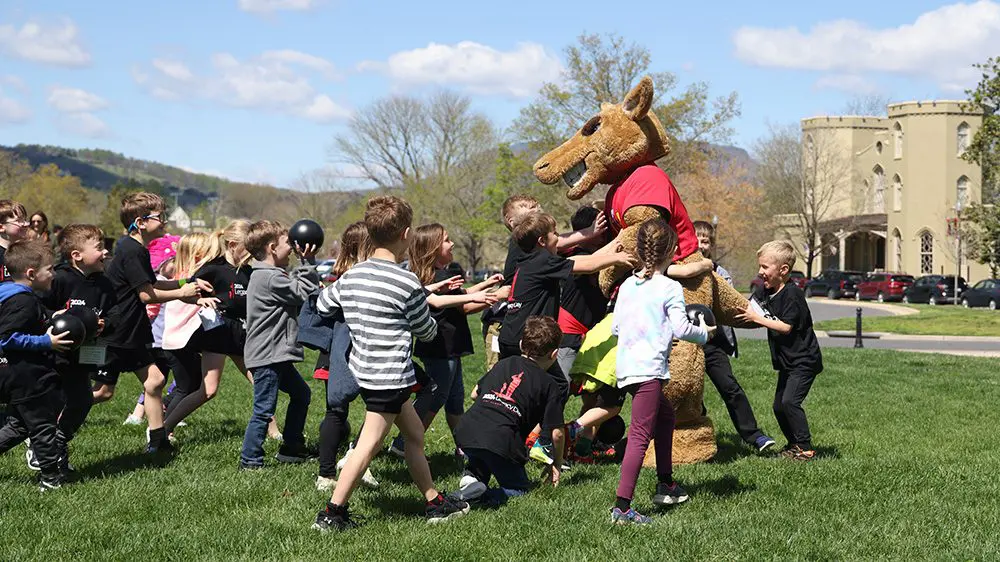 children running up to Moe the mascot