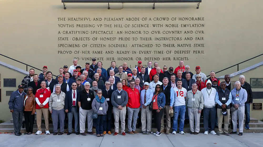 alumni standing in front of parapet