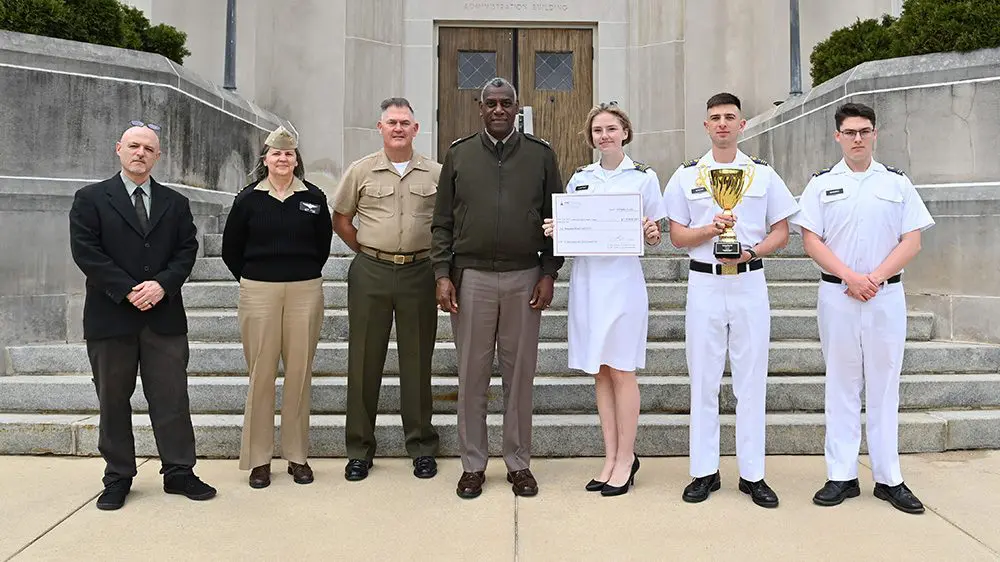 Maj. Gen. Wins and other officials stand with cadets, smiling