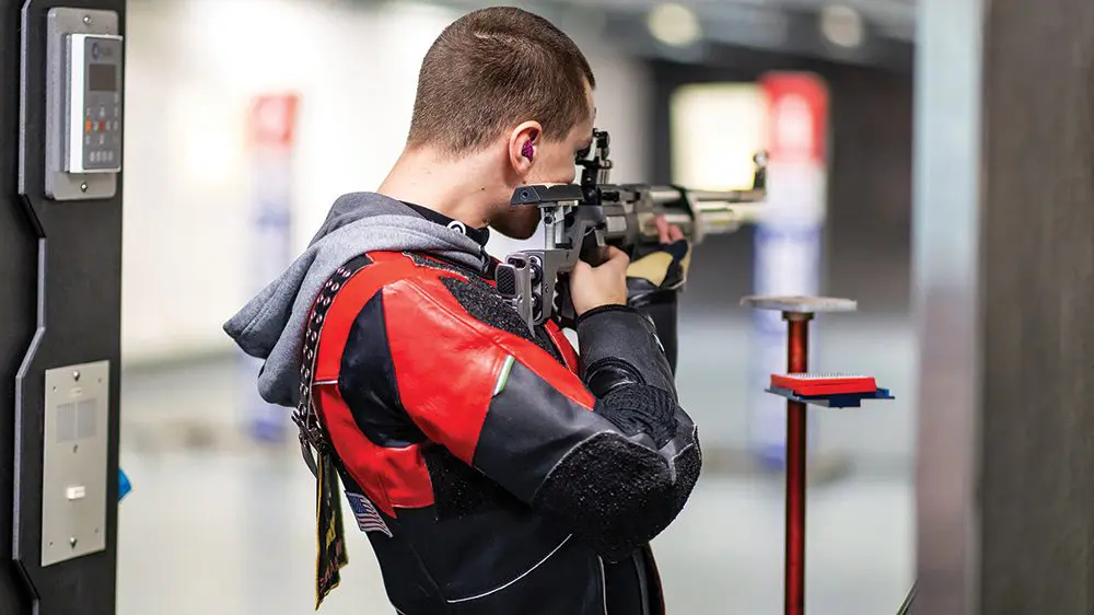 rifle athlete aiming rifle at target