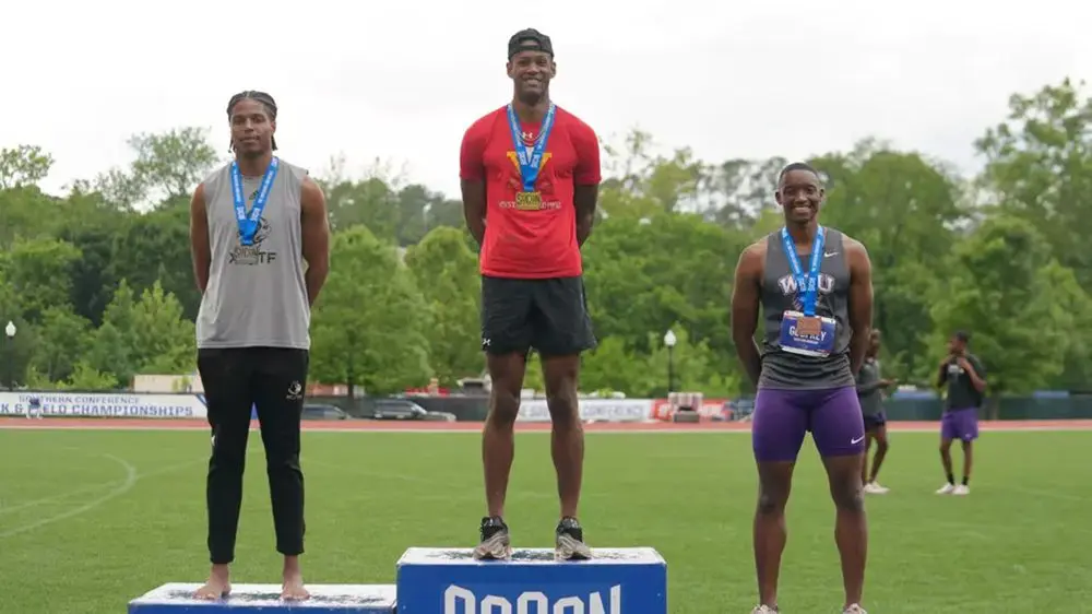 male track athletes smiling with medals around their necks