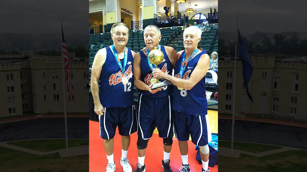 Gary Kaylor and other basketball players holding trophy, smiling