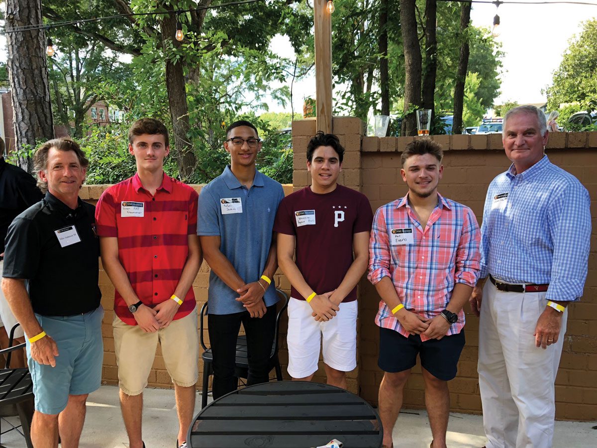 Charlotte chapter alumni standing with a group of young men