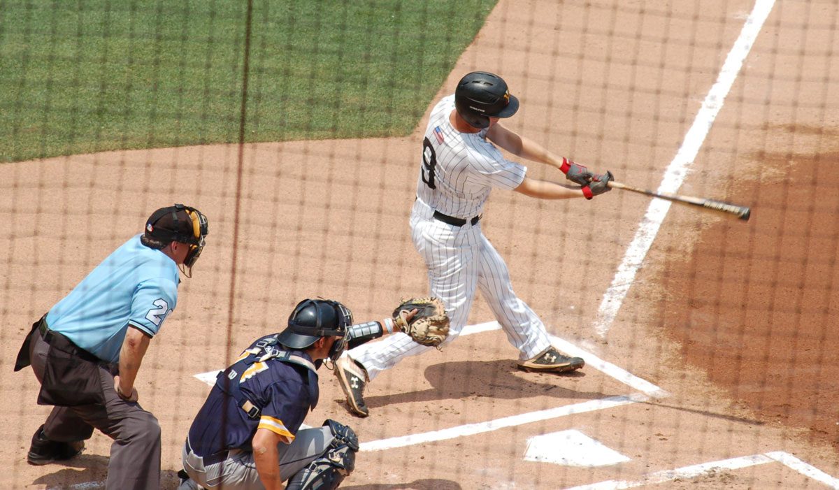 VMI baseball player swinging bat in game