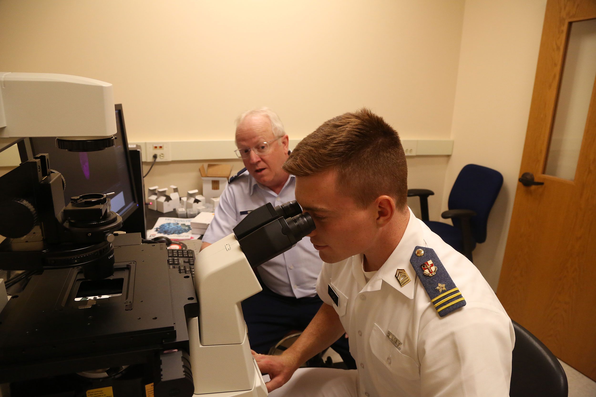 A VMI cadet looking through a microscope