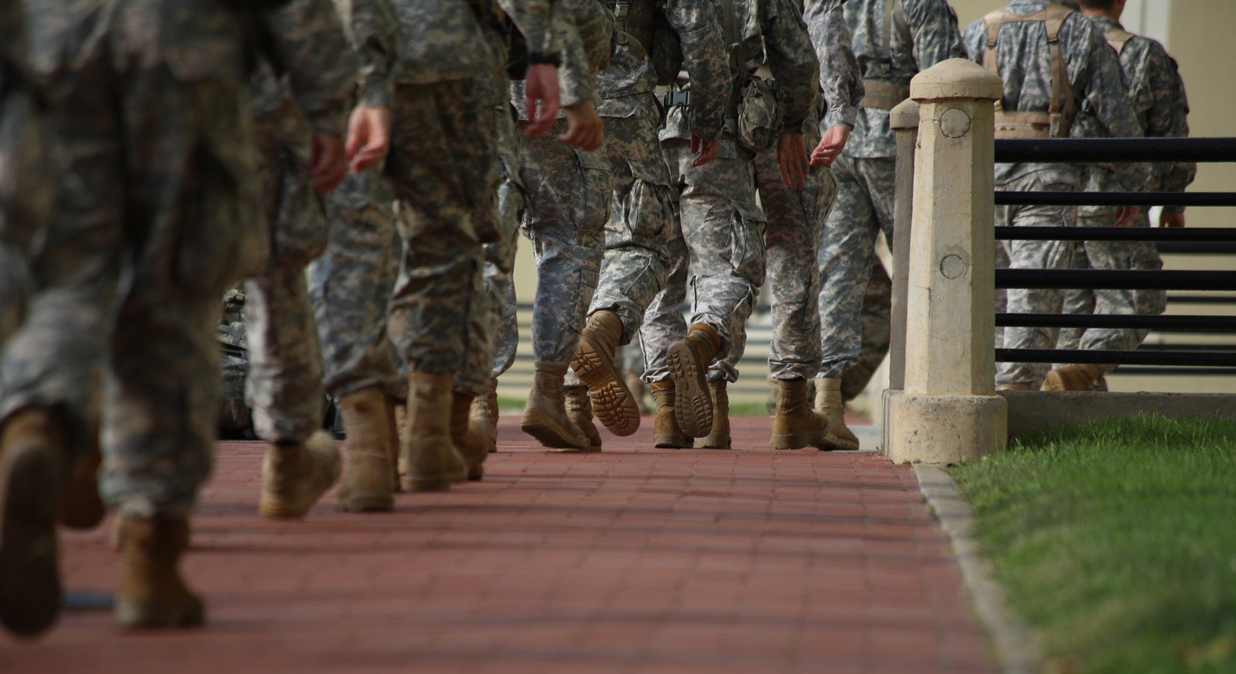 group of soldiers marching on brick path