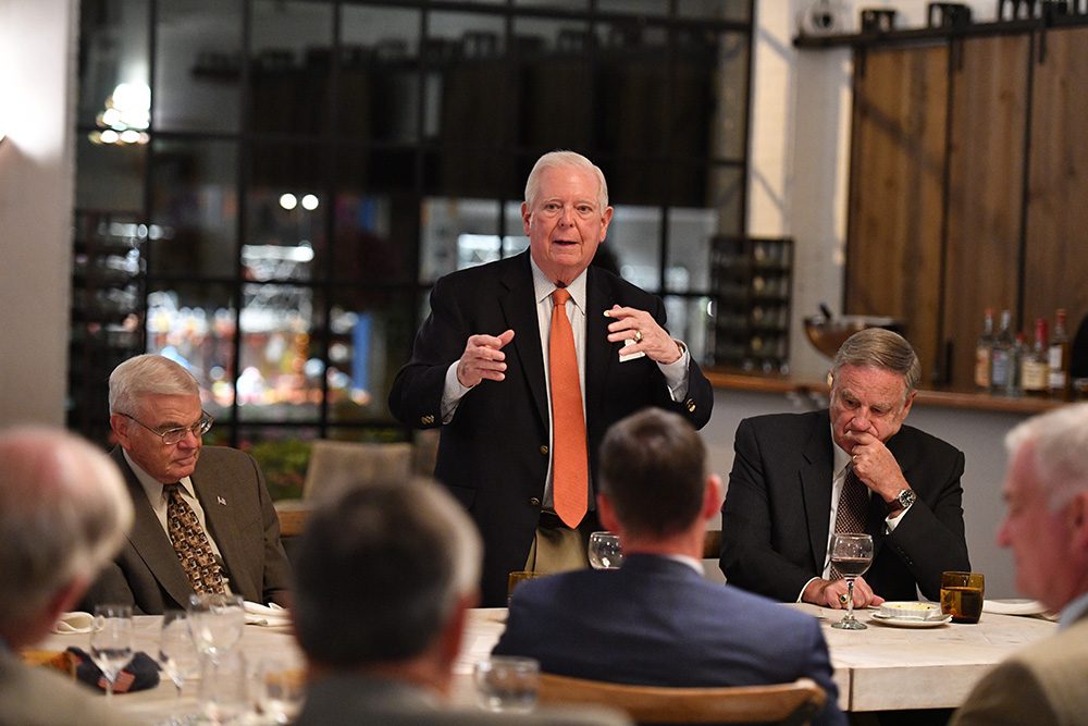 G.G. Phillips speaking to a group of people seated at a table.