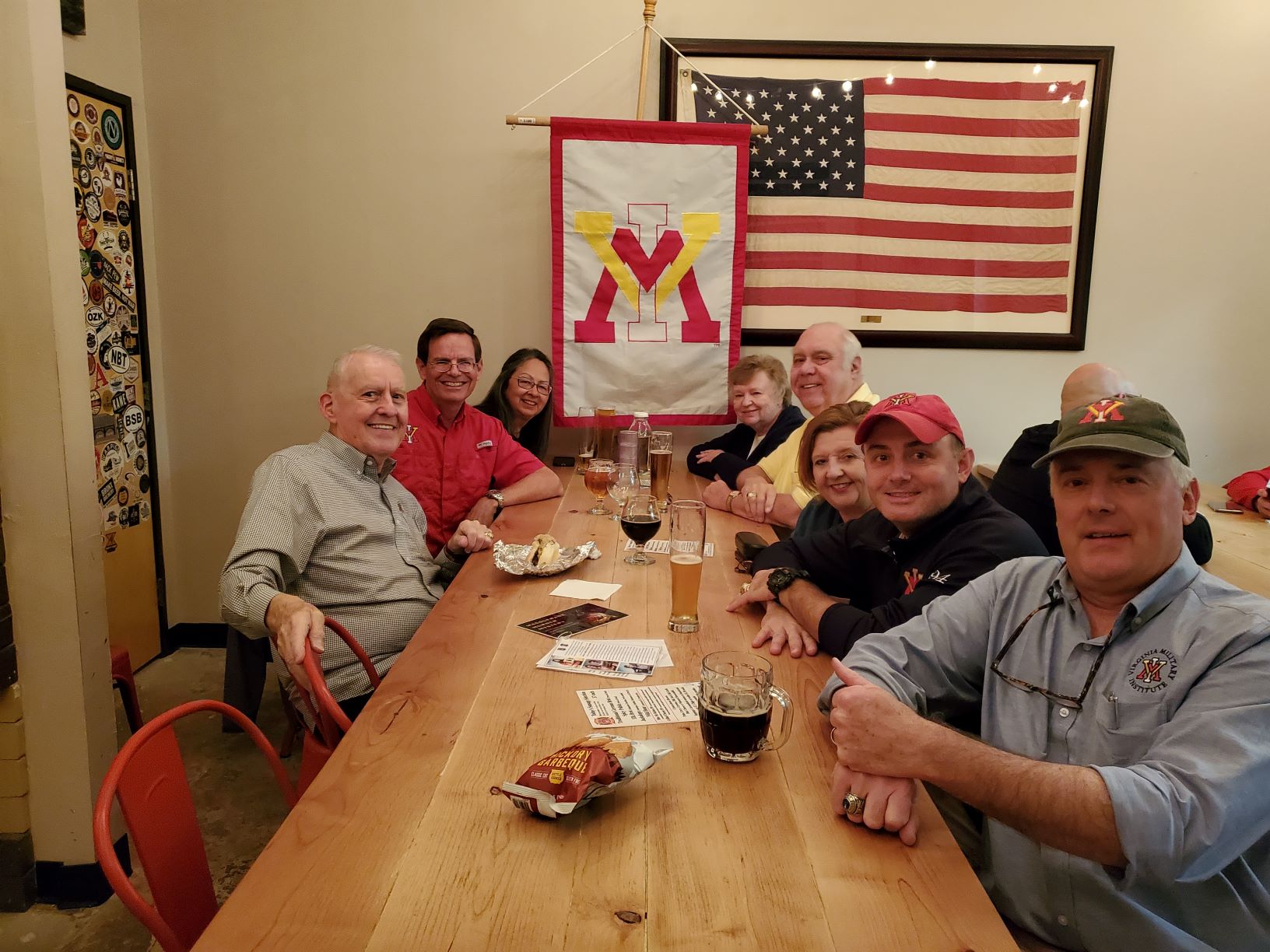 Group of people seated at dining table with VMI flag in the center.