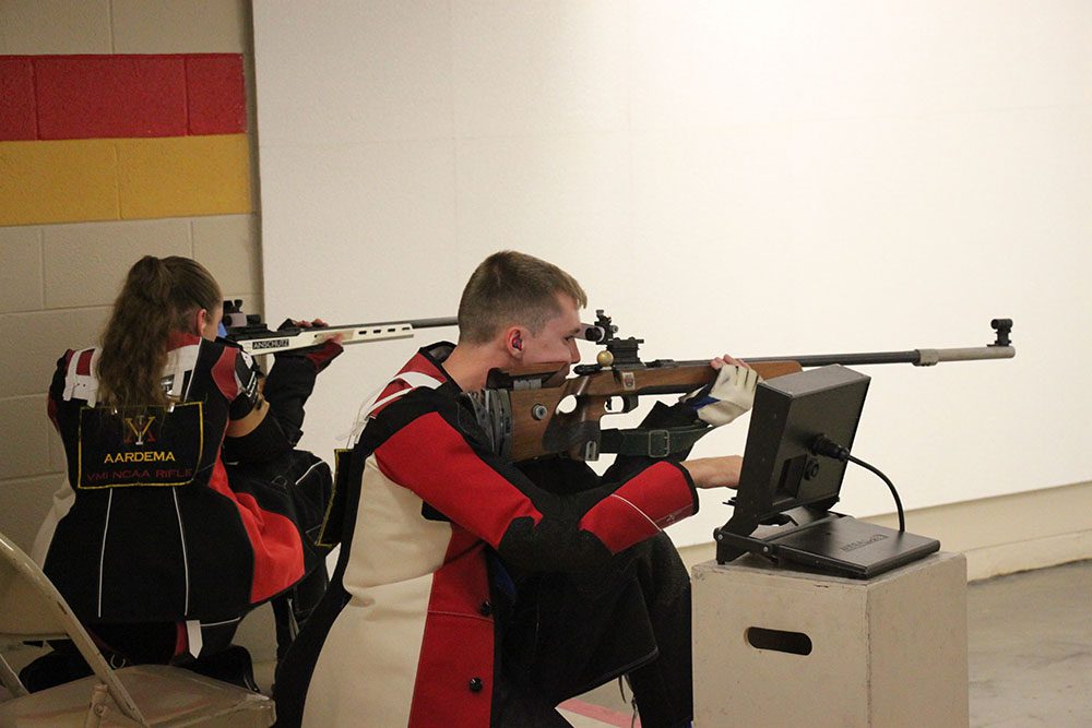 two members of rifle team aiming rifles at targets