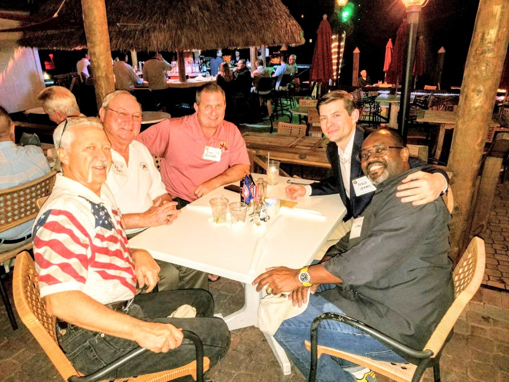 Group of men seated at table, smiling.