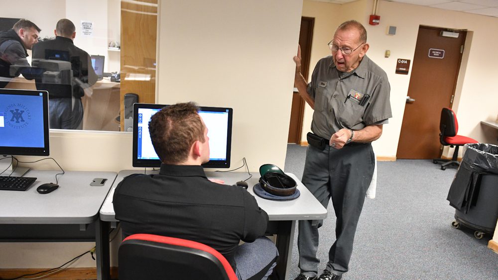 Barney Odenhal '58 speaking to a cadet.