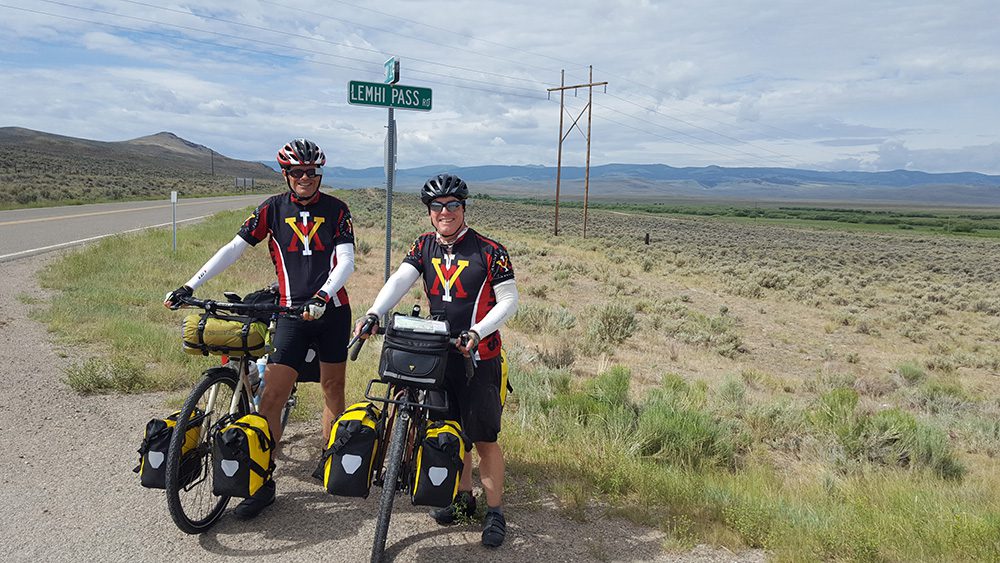 two people with bicycles standing and smiling.