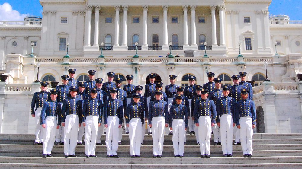 glee club dressed in coatee standing on steps