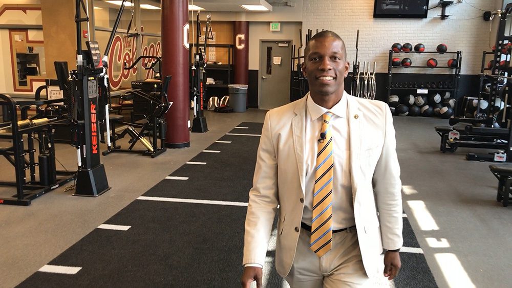 Man standing in weight room smiling