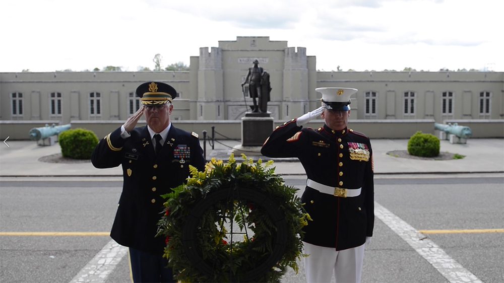 two men stand in uniform saluting