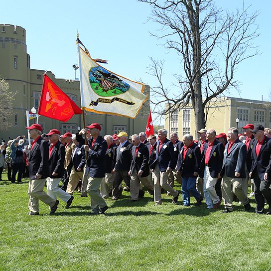 Reunion class marching across parade field into barracks
