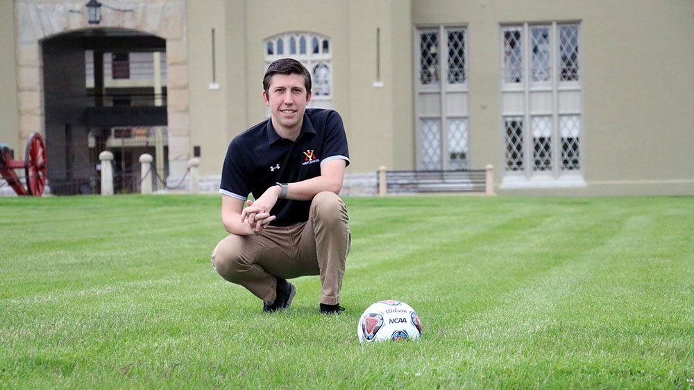 Max Watson kneeling on ground, smiling