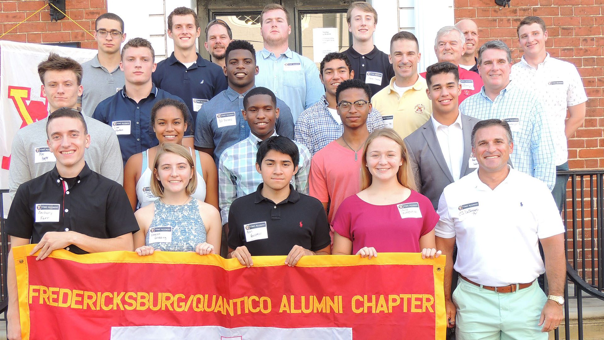 Group of people posing with a flag that reads 