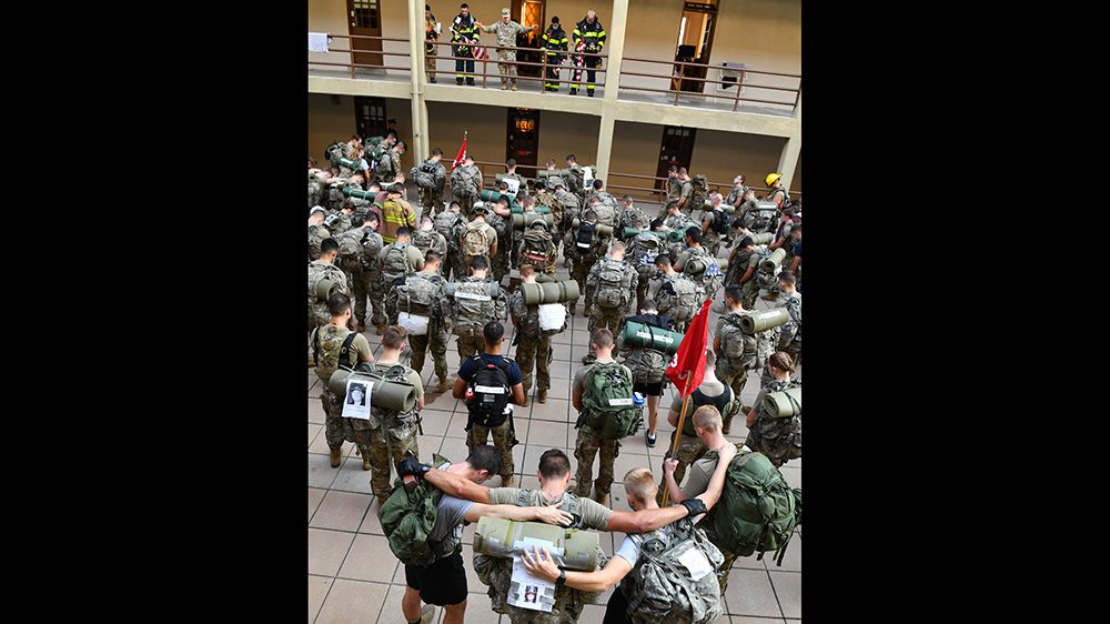 cadets with arms around each other, praying