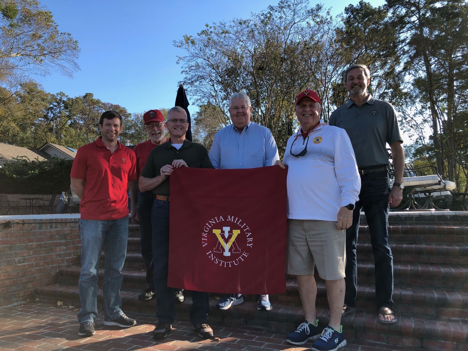 group holding VMI flag and smiling