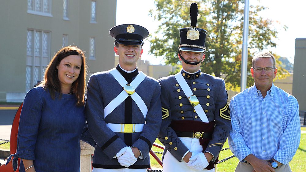Cheryl Cathcart (far left) standing with husband Charlie Cathcart (far right) and sons Trey and Cole Cathcart in their cadet uniforms (center)