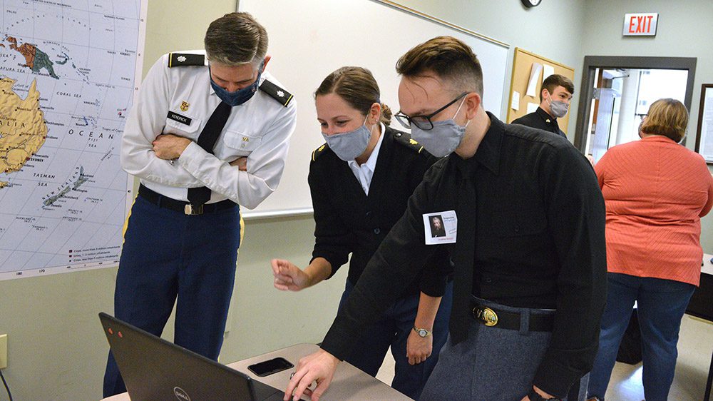 three people observing content on a laptop