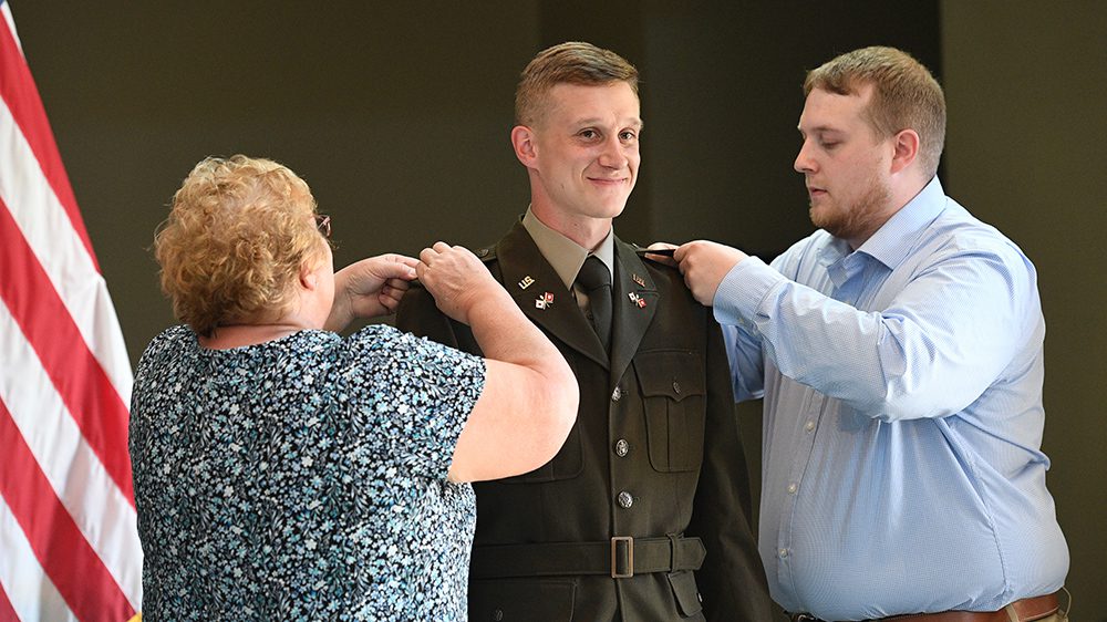 man having shoulder boards pinned on