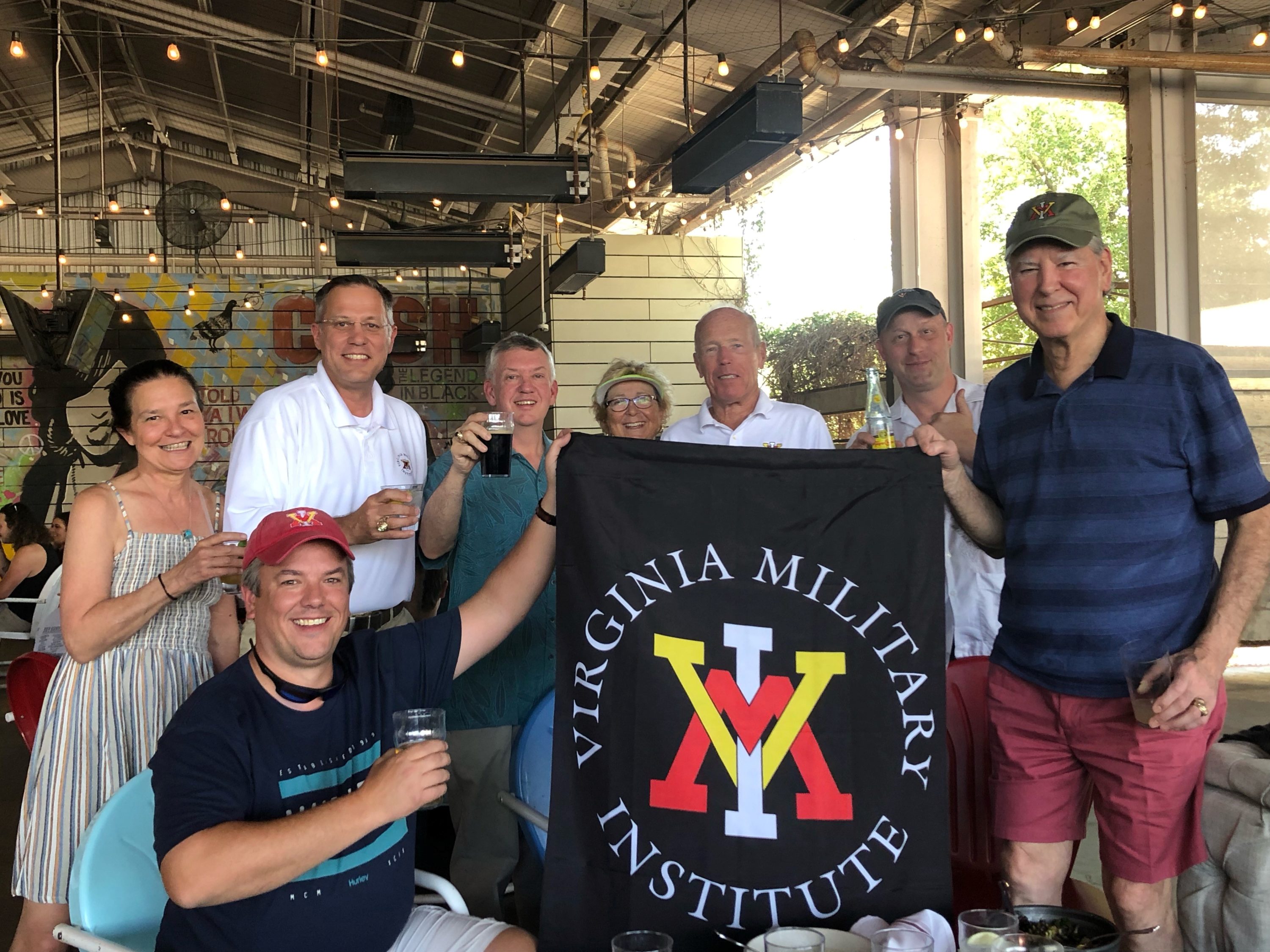 group holding VMI flag and smiling