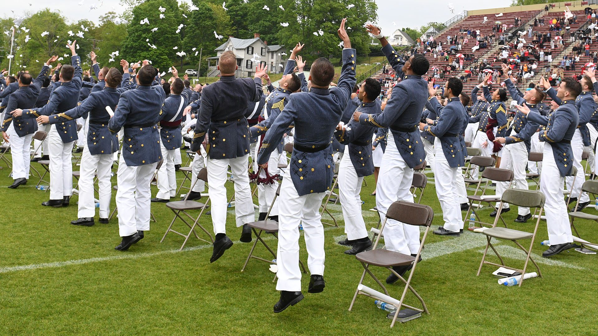 cadets throwing gloves in the air at graduation at Foster Stadium