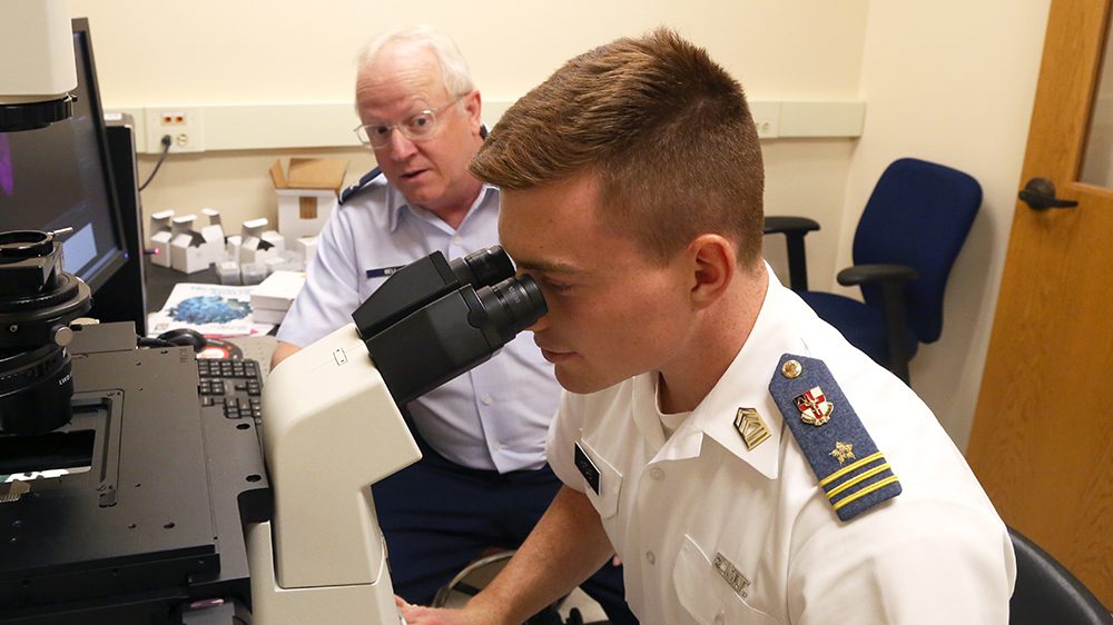 cadet looking through microscope
