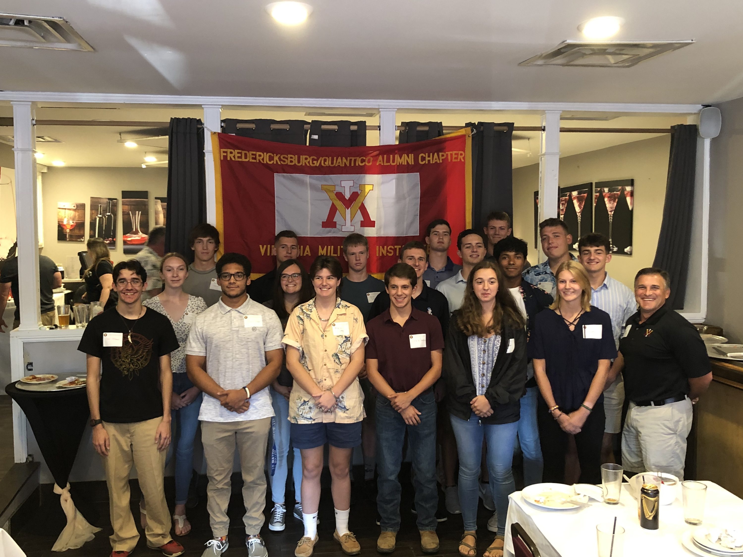 group of people posing with VMI flag, smiling