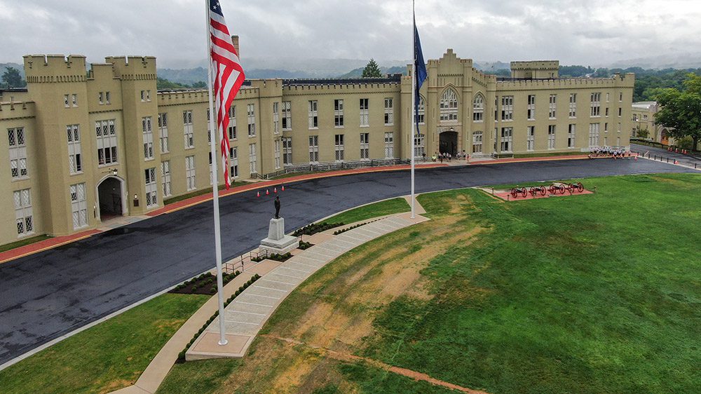 wide shot of old and new barracks with flag poles, cannons, and Marshall Statue in foreground