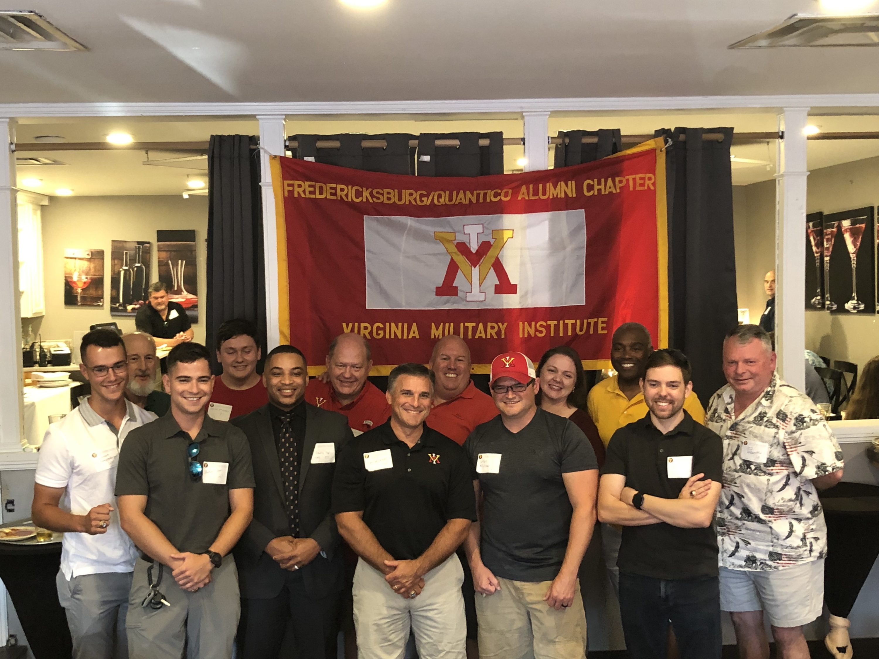 group of people posing with VMI flag, smiling