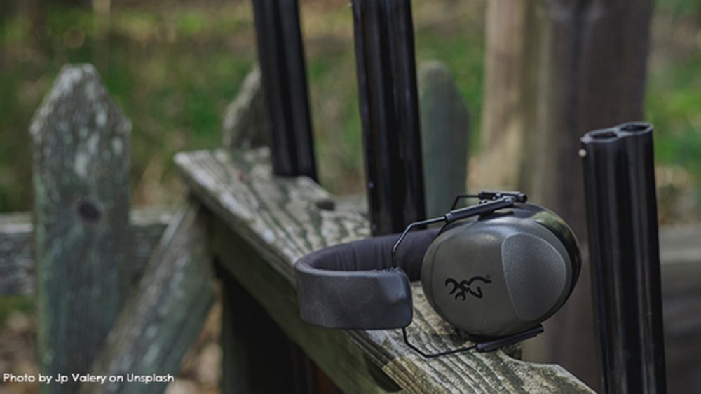 earmuffs sitting next to rifles