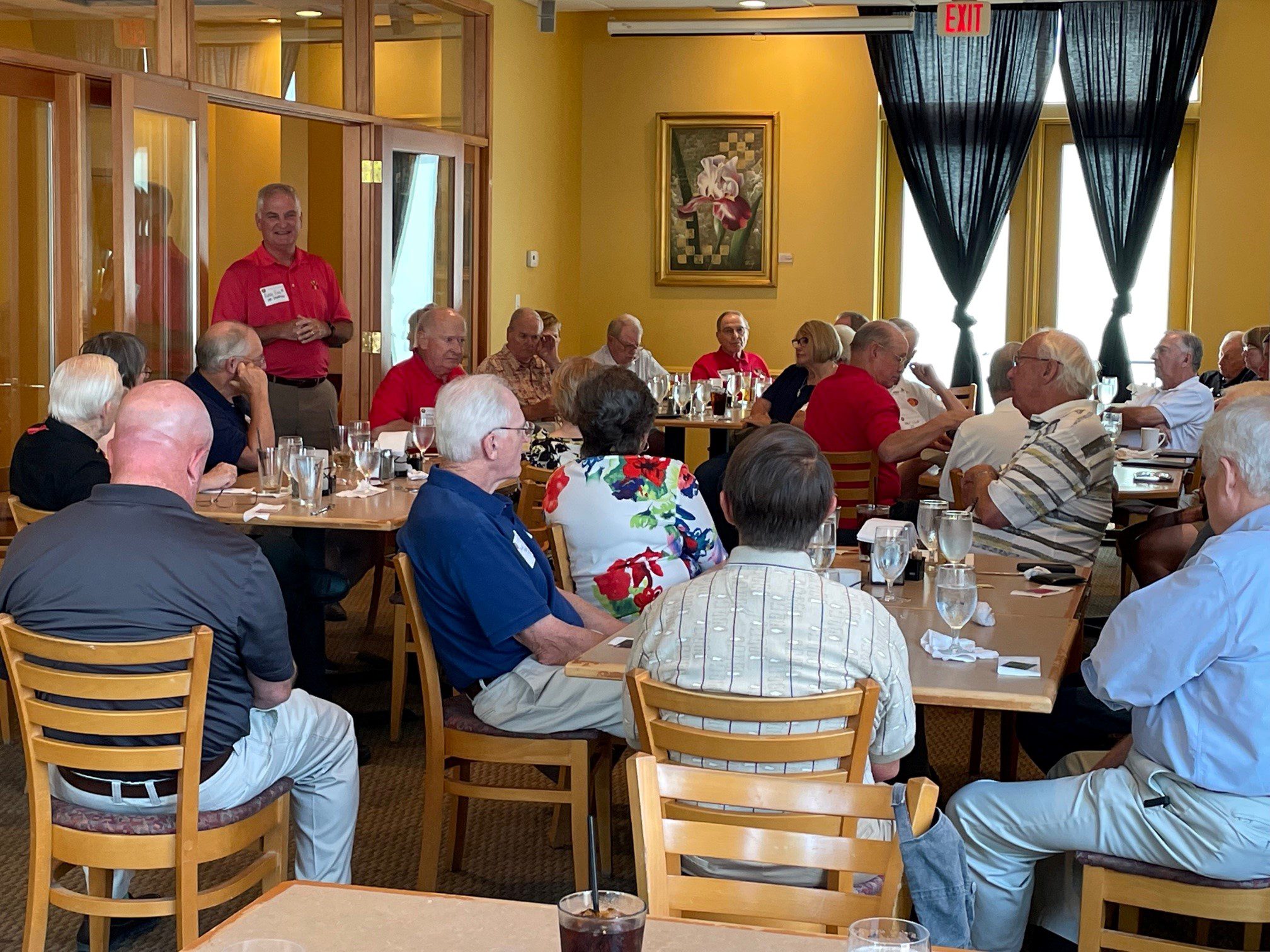 Meade King addressing a group of individuals seated at tables.