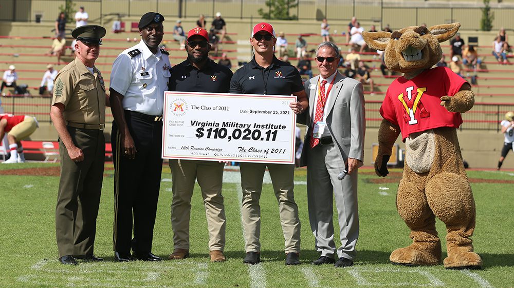 Men posing with Moe, holding check from Class of 2011