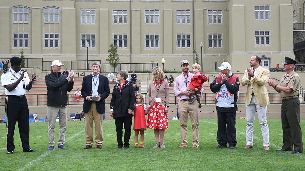 group of people gathered on football field, clapping