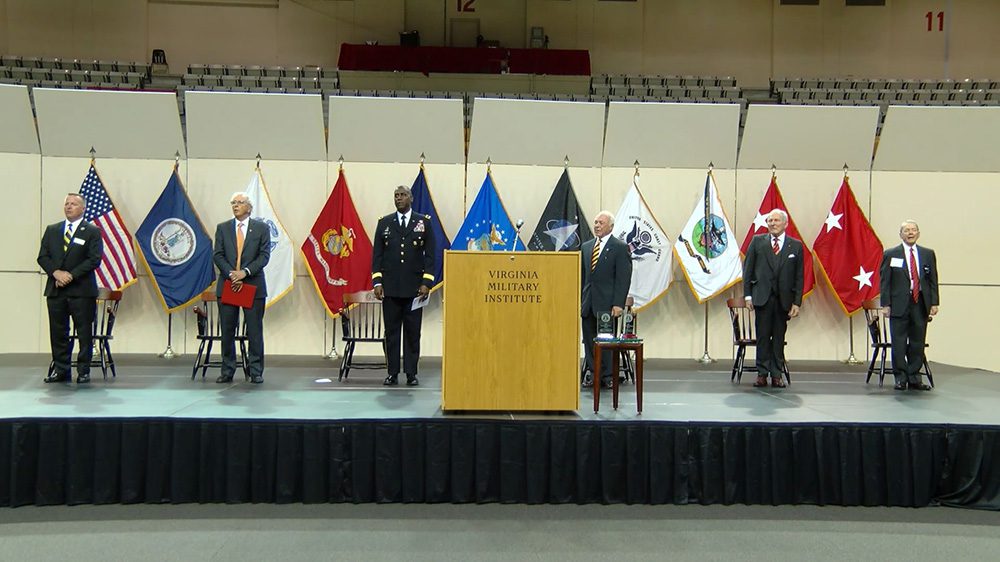 men standing on stage in Cameron Hall