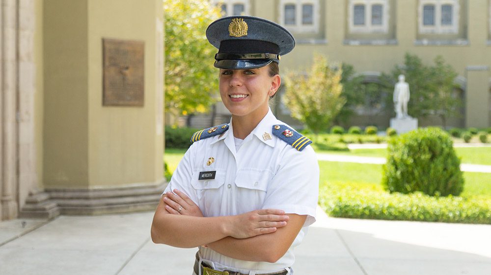 Kasey Meredith '22 stands with arms crossed, smiling.