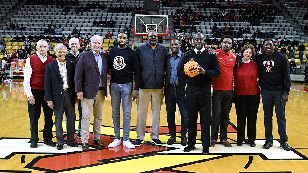 Maj. Gen. Cedric Wins '85 and former VMI athletes pose on basketball court