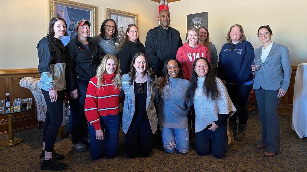 group of VMI alumnae gathered with Maj. Gen. Cedric Wins '84, all smiling.