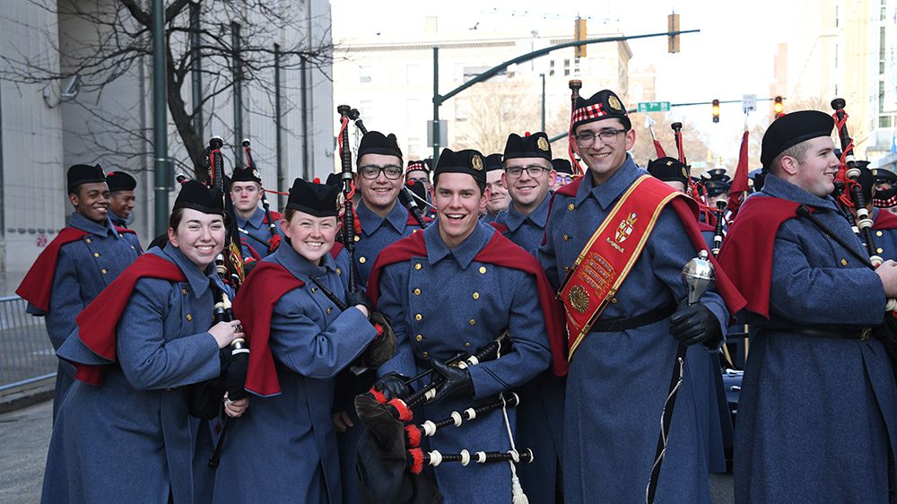 Bagpipers posing and smiling.