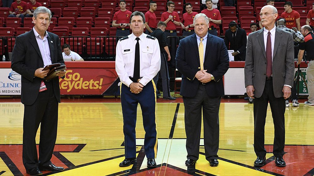 four men standing on basketball court