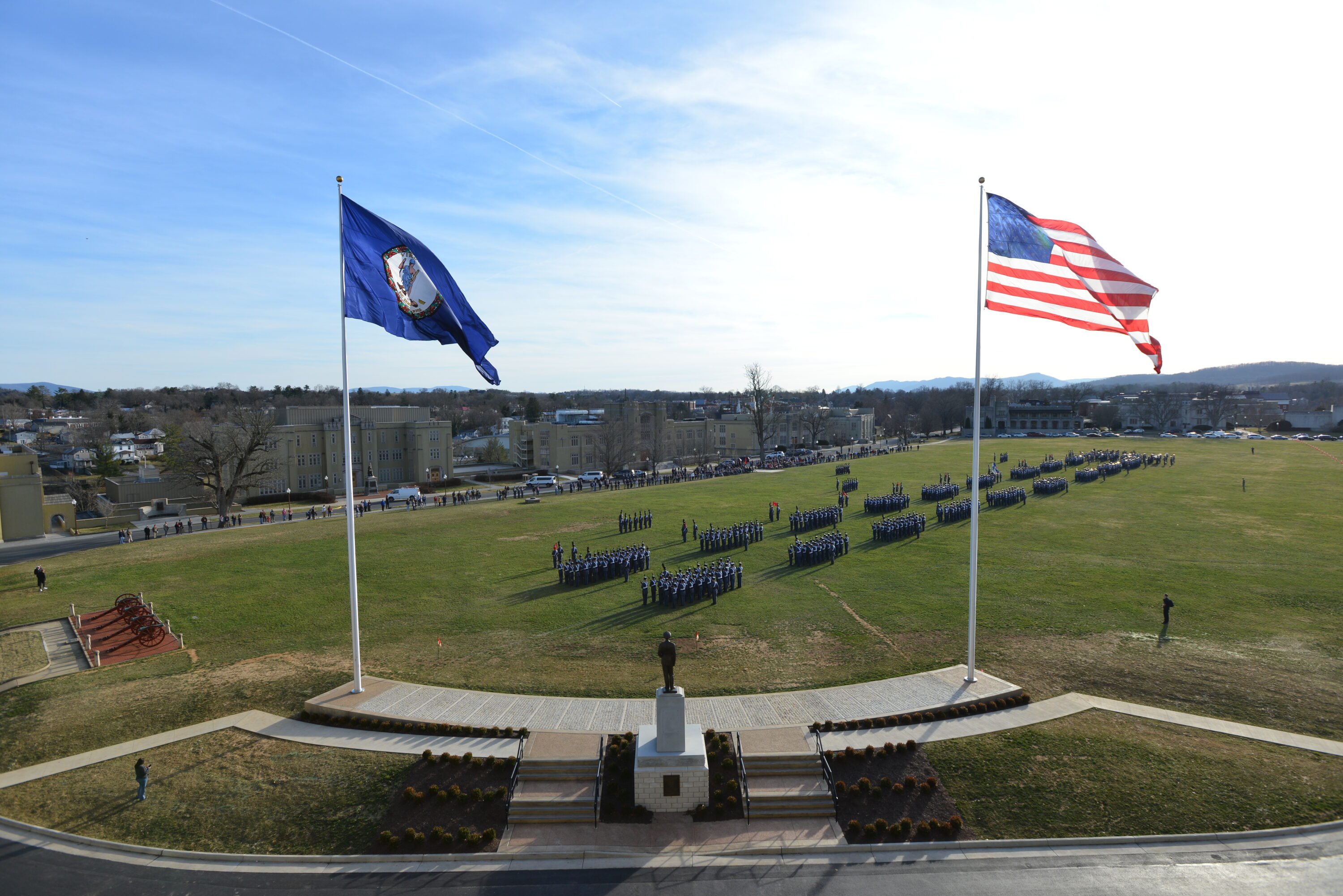 aerial shot of cadets in formation on parade ground, and flags/Marshall statue