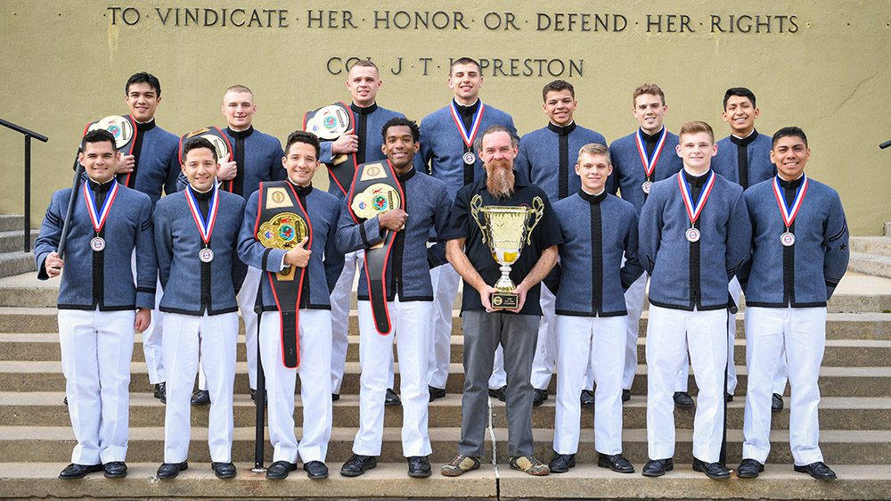 Coach Joe Shafer posing with the VMI club boxing team in front of the parapet after returning home with the trophy from the United States Intercollegiate Boxing Association National Championships in Atlanta, Georgia.